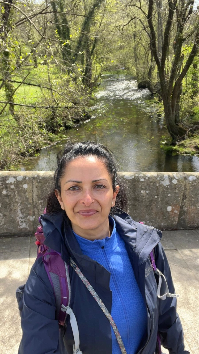 Mit Lida Pilgern - Pilgerreise-Coaching - Eine Nahaufnahme eines weißen Birkenstamms mit dunklen, augenförmigen Astlöchern in der Rinde vor dem Hintergrund üppigen grünen Laubs.